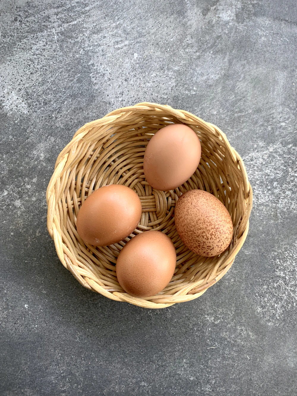 Brown eggs in a woven basket, an illustrative produce photograph